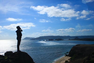 黑夹克男子站在海滨白天
